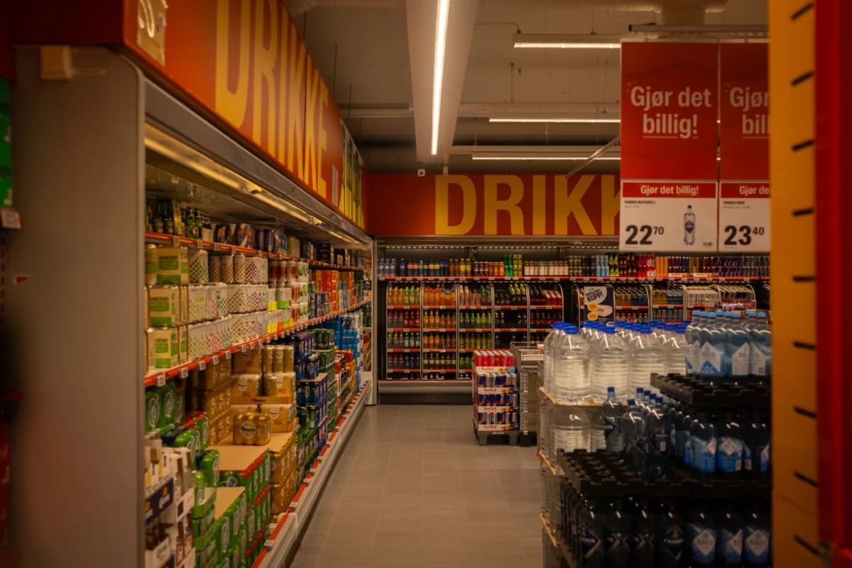 Bright supermarket aisle lined with drinks and products