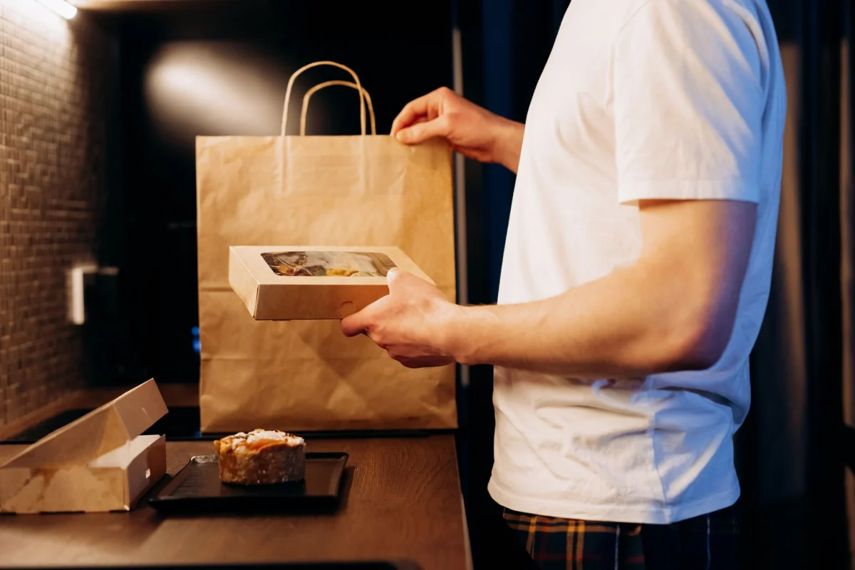 Person holding a takeout food delivery box