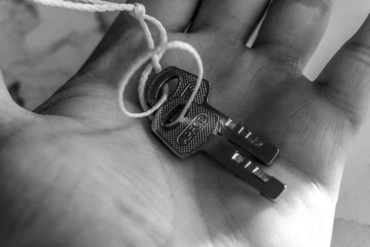 Detailed black and white photo of keys held in a hand, emphasizing texture and detail.