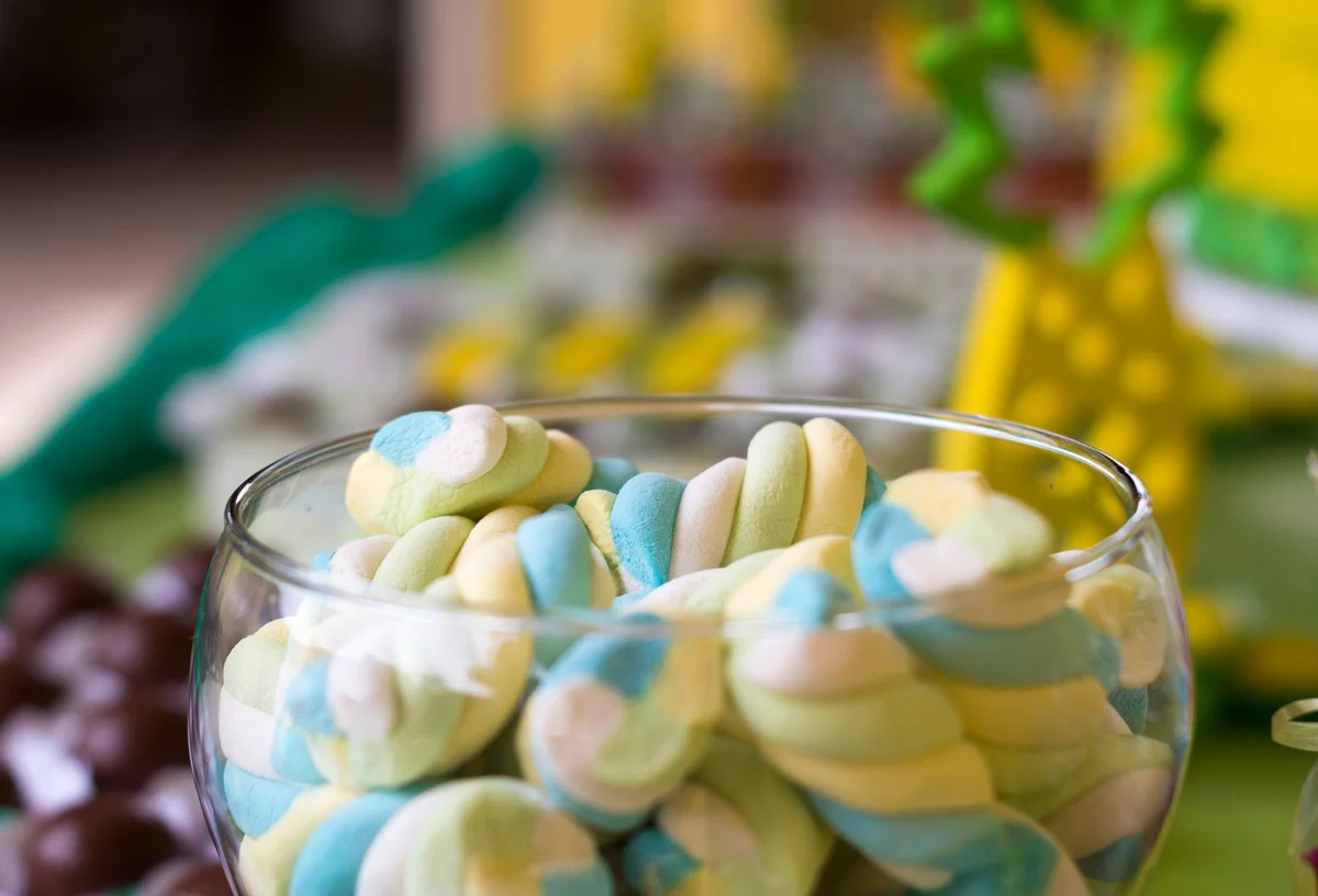 Colorful twisted marshmallows in a glass bowl, perfect for candy-themed decor