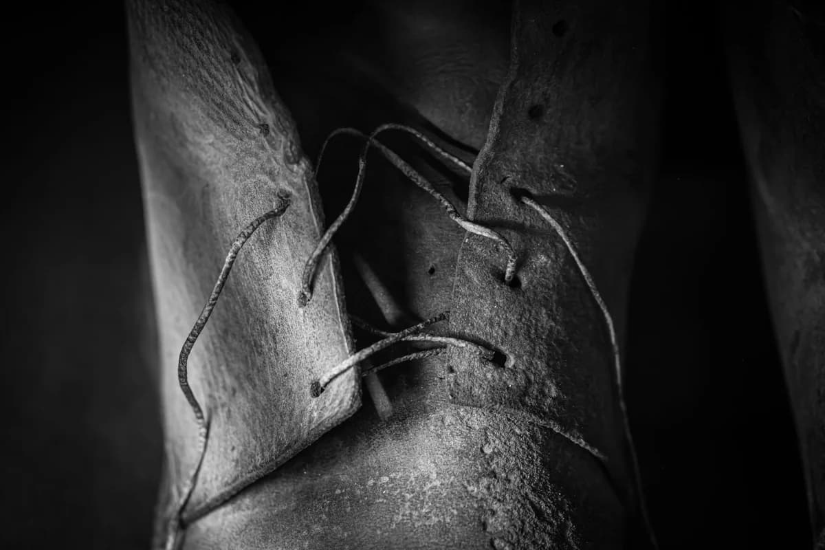 Detailed close-up of a vintage leather shoe in black and white, highlighting texture.