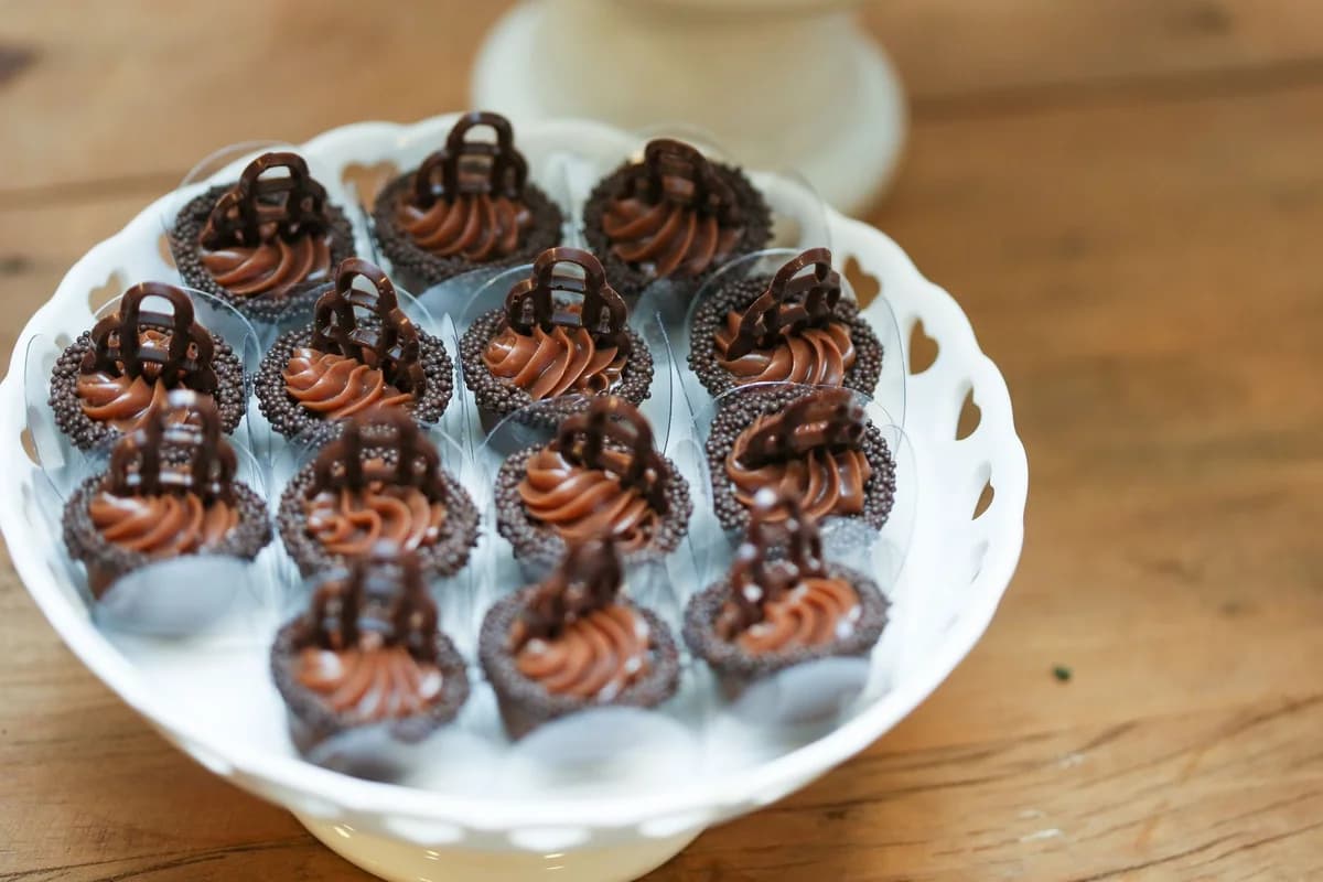 Tempting chocolate cupcakes with frosting and sprinkles arranged on a decorative stand.
