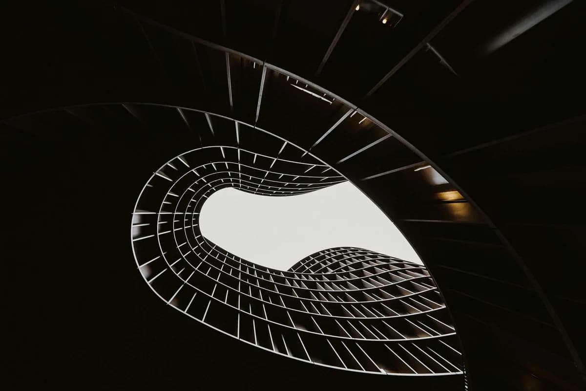 Abstract view of a modern spiral staircase in black and white highlighting architectural design.