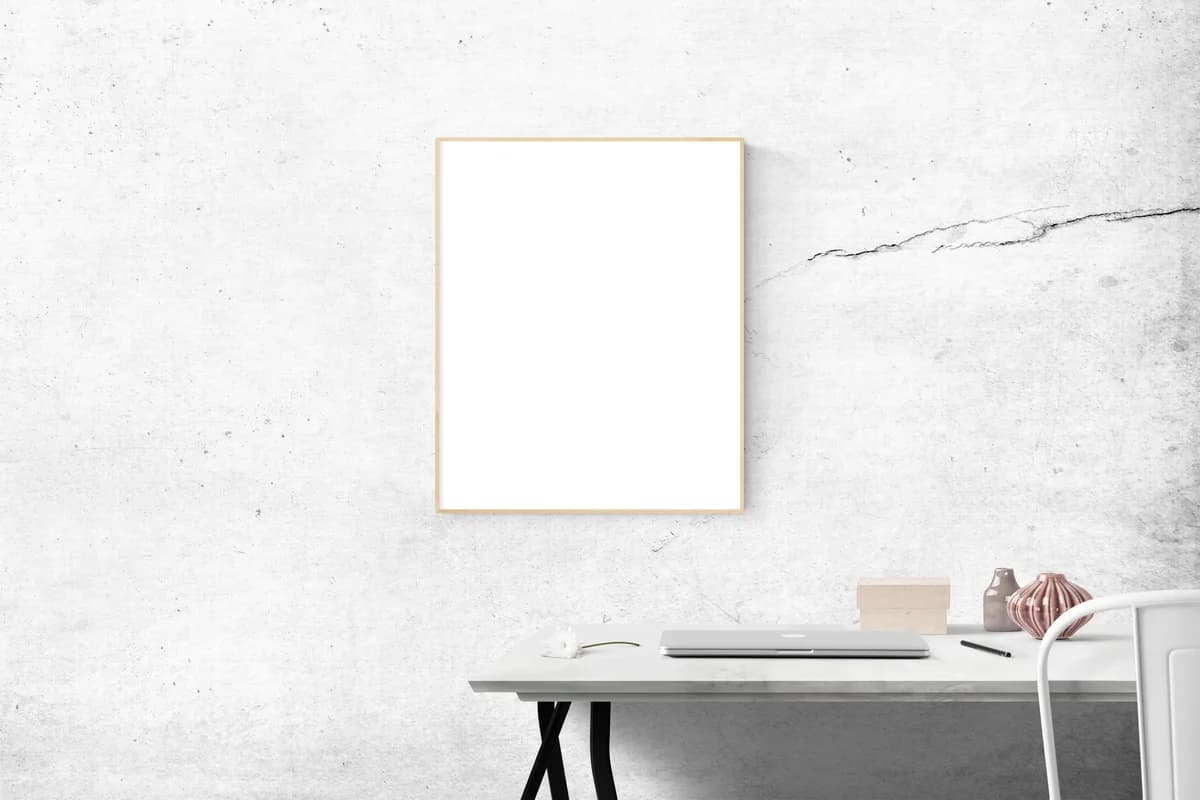 A contemporary minimalist workspace featuring a blank picture frame on a concrete wall.