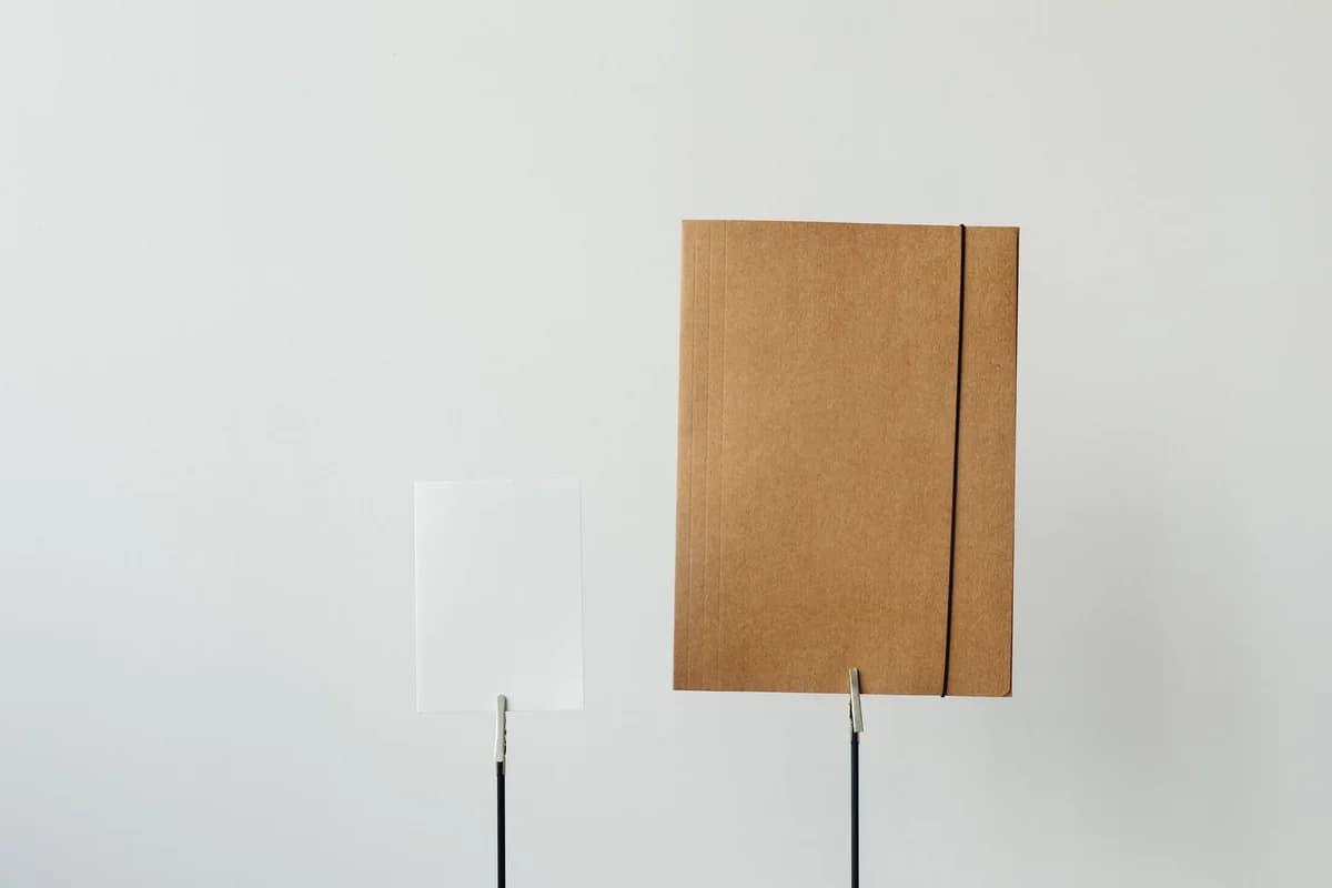 Simple minimalist office setup featuring a paper and brown folder on a white background.